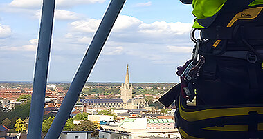 Rope access expert applying waterproofing coatings to protect a building's exterior